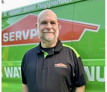 Male Employee Standing In Front of Servpro Vehicle